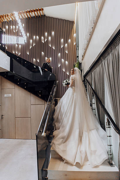 istock A bride is walking down a staircase in a wedding dress 2207735168