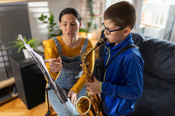 istock Mother teaching son to play saxophone at home 2207736639