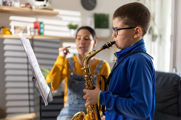 istock Mother teaching son to play saxophone at home 2207736650