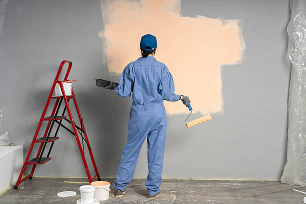 istock Building contractor painting grey wall with roller brush 2207736723