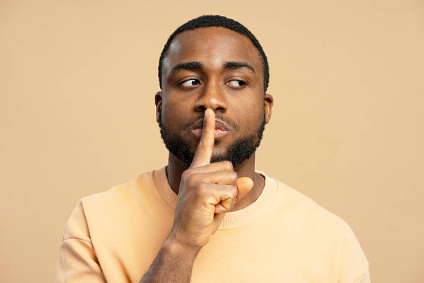 istock African American man showing silence sign with finger on lips 2207737544