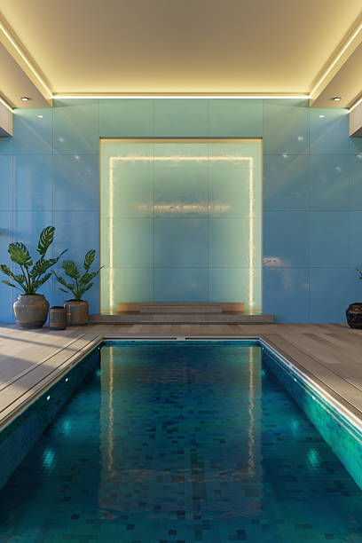 istock A stylish indoor swimming pool features serene blue tiles and soft lighting, creating a relaxing atmosphere. Potted plants enhance the modern design in the spacious environment. 3d render 2207738268