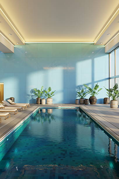 istock A serene indoor pool area features sleek lounge chairs and tall potted plants, illuminated by natural light streaming through large windows, creating a relaxing ambiance. 3d render 2207738271