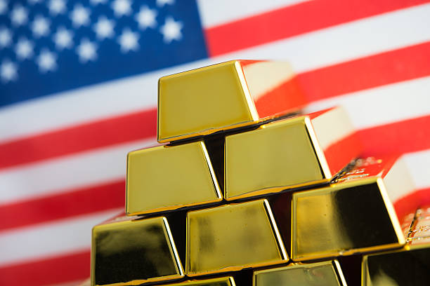 istock Stacked gold bars with American flag background. 2207741002