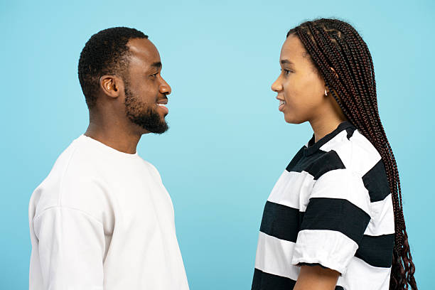 istock Young couple smiling and looking each other isolated on blue background 2207741276