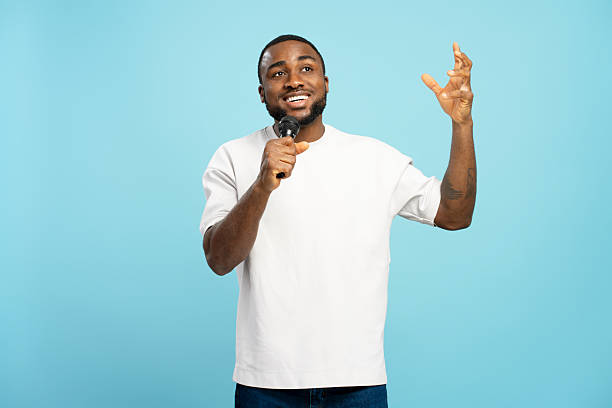 istock Happy African American singer performing with microphone on blue background 2207741890