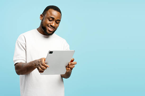 istock Smiling African American man using digital tablet on blue background 2207741892