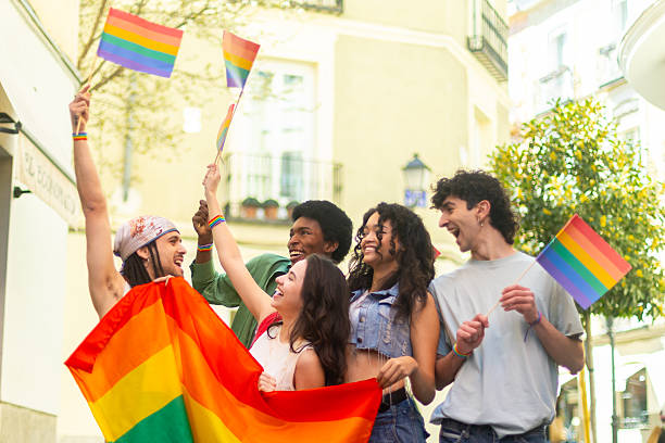 istock Young activists waving rainbow flags at pride parade celebrating lgbtq plus community 2207743365