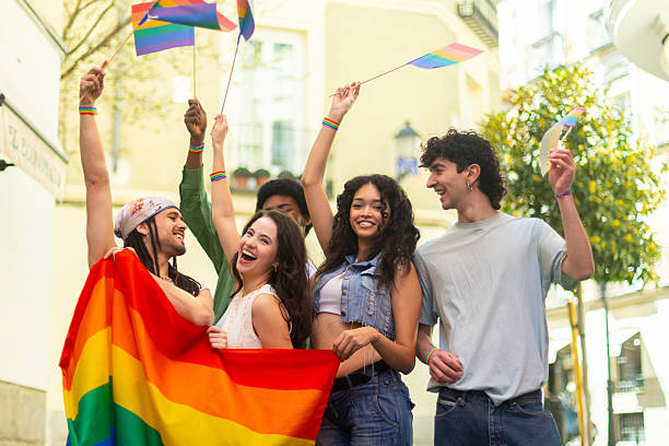 istock Young activists waving rainbow flags at pride parade celebrating lgbtq plus community 2207743394