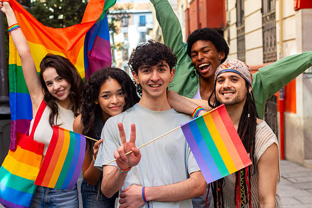 istock Young activists showing rainbow flags and peace sign at pride parade 2207743396