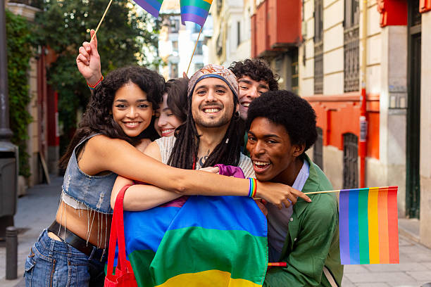 istock Happy multi ethnic friends celebrating lgbtq plus pride with rainbow flags 2207743402