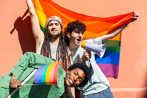 istock Activists holding rainbow flag and megaphone at pride parade 2207743446