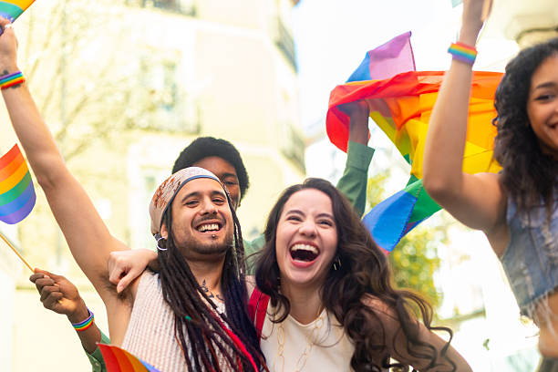 istock Young activists celebrating with rainbow flags at pride parade 2207743451
