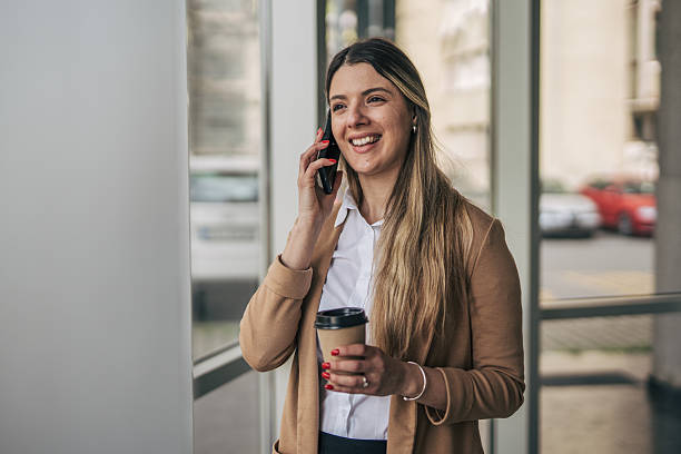 istock Smiling businesswoman talking on phone and drinking coffee 2207743642