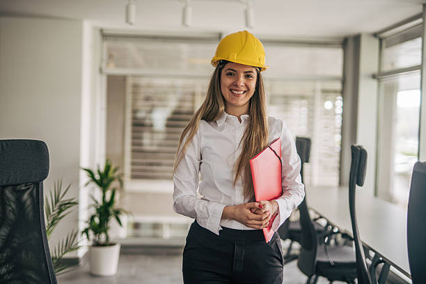 istock Female engineer smiling and holding a folder in the office 2207745011
