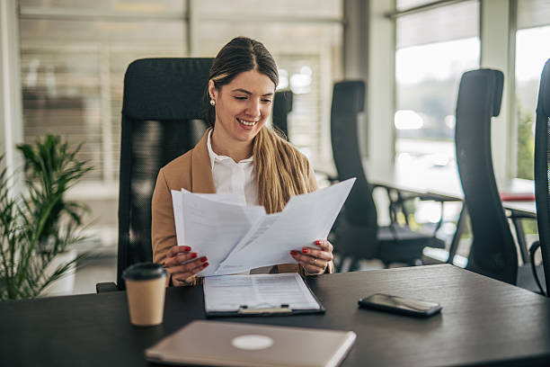 istock Businesswoman reading documents at office desk smiling 2207745344