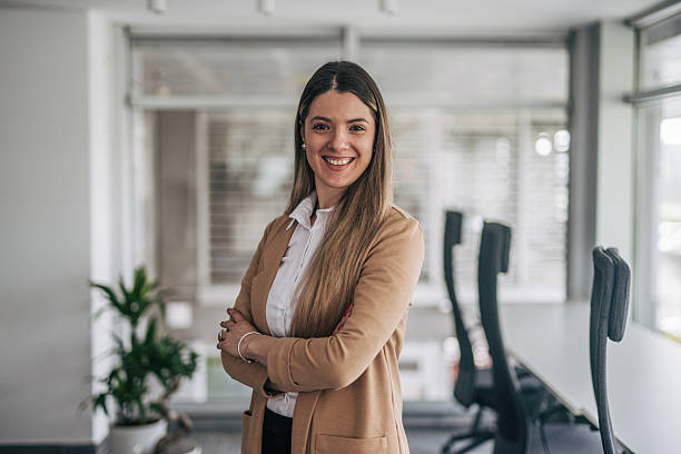 istock Young businesswoman smiling with folded arms in modern office 2207745541
