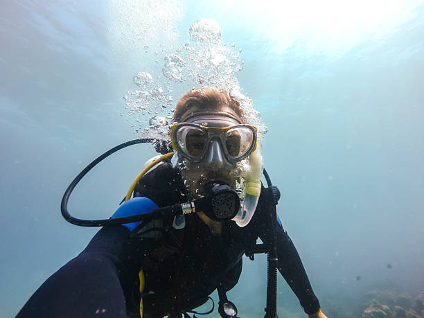 istock Diver exploring underwater coral reef while taking a selfie in clear blue waters 2207747150