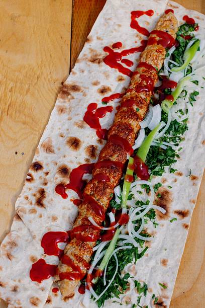 istock Delicious kebab wrap with fresh herbs and sauce. 2207751128