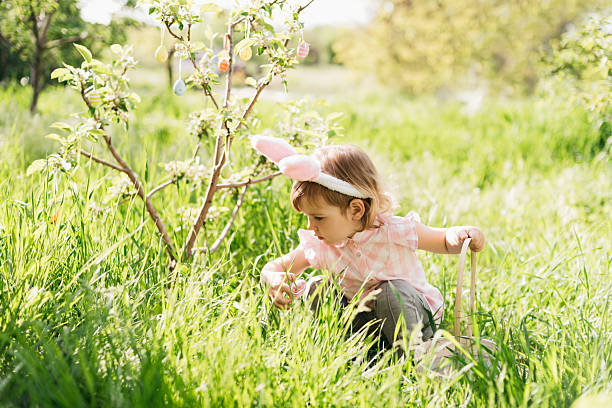 istock Baby with basket full of colorful eggs. Easter egg hunt. 2207751187