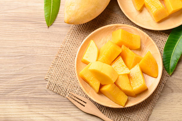 istock Cube mango on wooden plate ready to eating, Tropical fruit in summer season, Table top view 2207753130