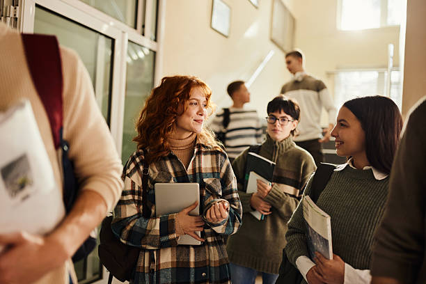 istock Happy high school students talking on the move in a hallway. 2207760936