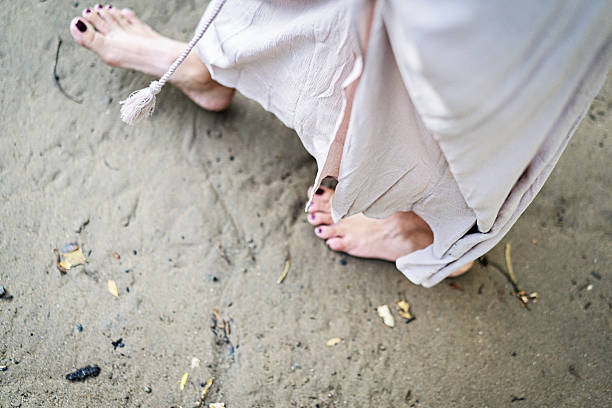 istock feet in the sand 2207762652