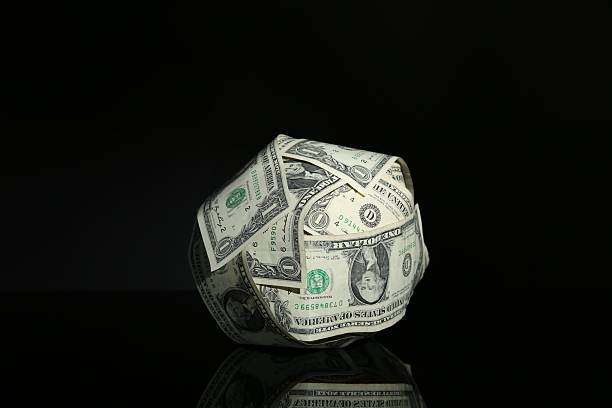 istock Ball made of dollars on black mirror surface 2207764149
