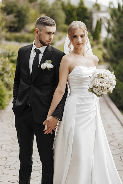 istock A bride and groom are standing together on a path, holding hands 2207764286