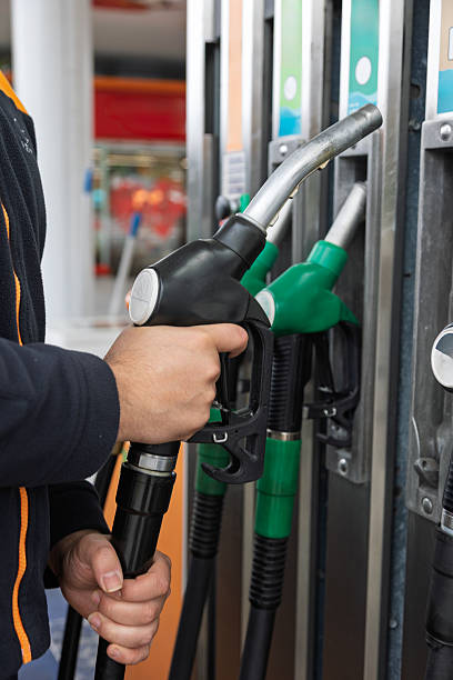 istock Driver picking up black fuel nozzle at gas station 2207764573