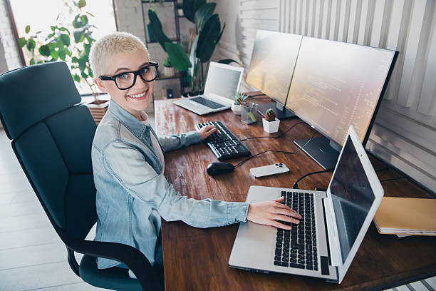 istock Modern programmer woman working with multiple screens at home office in casual style 2207764778