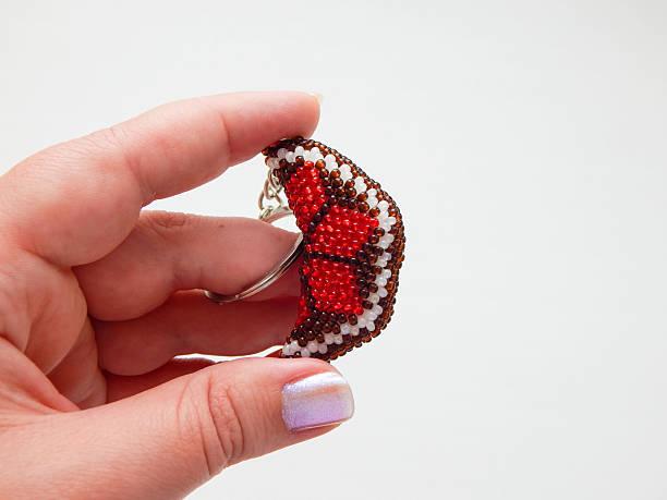 Bead colorful key chain in a female hand. Colorful keychain lies on a woman's palm