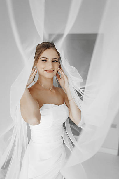 istock A bride is posing for a picture with her veil covering her face 2207765083
