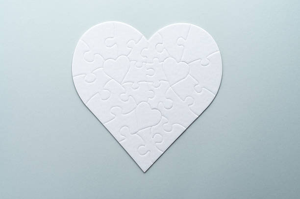 istock White heart-shaped jigsaw puzzle on a grey background. Symbolizing love, connection, and unity, this minimalist design is perfect for themes of relationships, teamwork, and problem-solving. 2207765436