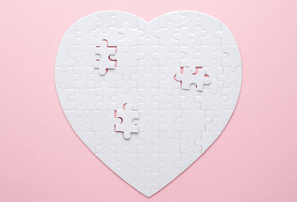 istock White heart-shaped jigsaw puzzle on a grey background, with several pieces missing and placed nearby. Symbolizing love, connection, or incompleteness, perfect for themes of relationships and emotions. 2207765445