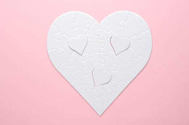 istock White heart-shaped jigsaw puzzle on a grey background, with several pieces missing and placed nearby. Symbolizing love, connection, or incompleteness, perfect for themes of relationships and emotions. 2207765453