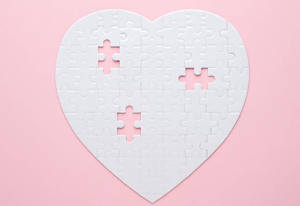 istock White heart-shaped jigsaw puzzle on a grey background, with several pieces missing and placed nearby. Symbolizing love, connection, or incompleteness, perfect for themes of relationships and emotions. 2207765457