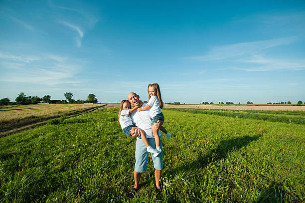 istock Two little sisters laugh joyfully while being held by their young father 2207765897