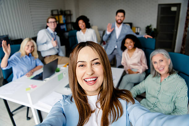 istock Cheerful group of diverse coworkers taking a selfie in a modern office setting 2207766313