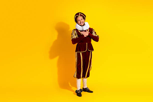 istock Man in medieval noble costume smiling against a yellow background 2207766441