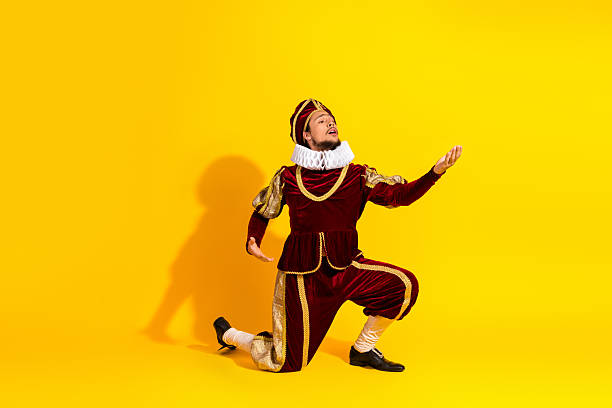 istock Young male cosplayer in royal costume performs against a yellow background 2207766444