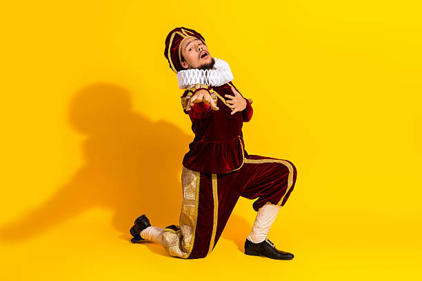 istock Young man in medieval noble costume performing on bright yellow backdrop with expressive gesture and passion 2207766446