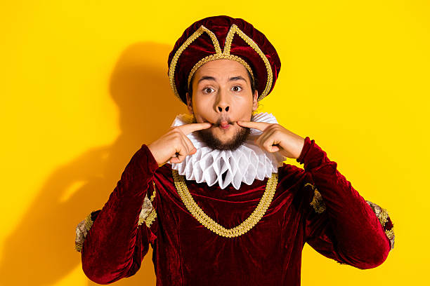 A young man portrays a vintage costume character with elegance, adding humor and charm to his portrayal on a bright yellow backdrop.
