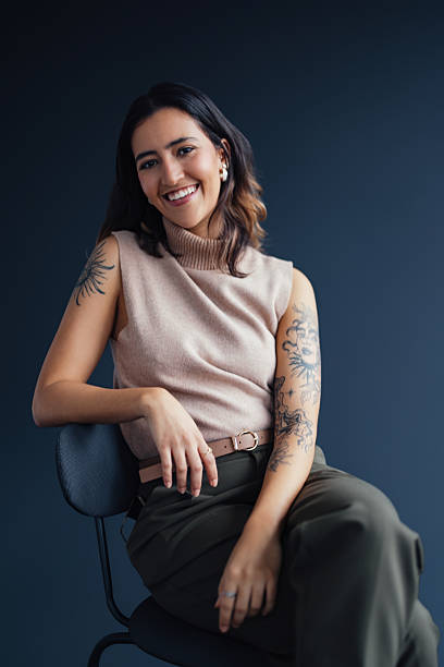 Charming Woman Smiling in Studio Portrait with Tattoos Showcased