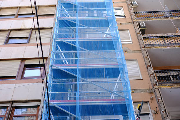 istock Urban building renovation with scaffoldings and blue protective netting 2207773658