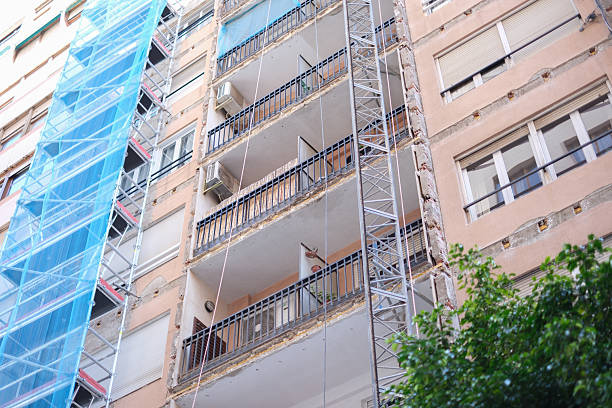 istock Apartment building under renovation with scaffolding and netting on facade 2207773718