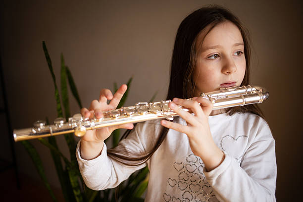 istock child playing flute. learning to play musical instruments at music school 2207774230