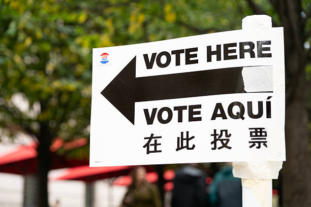November 7, 2023 - USA, New York, NY: A multi language Vote Here sign is taped to a pole near the Metropolitan Museum of Art on the upper east side of New York City. Spanish, English, Chinese Vote Aqui paper flyer.