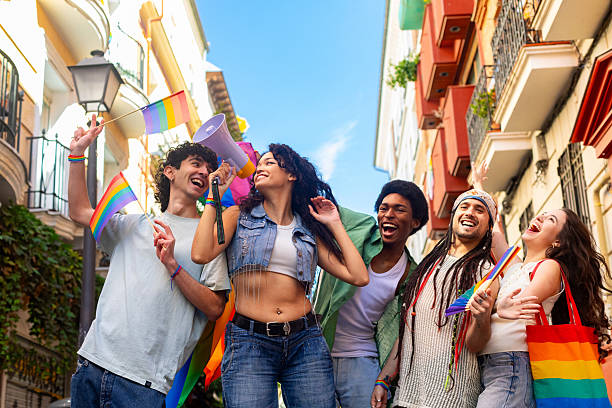 istock Young activists marching for lgbtq plus rights, using megaphone and waving rainbow flags 2207790004