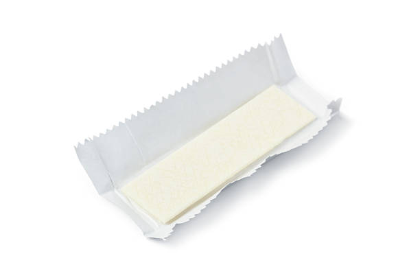 A stick of chewing gum in an unwrapped wrapper isolated on a white background